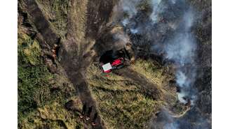 Bombeiros voluntários, membros da Brigada do Alto Pantanal andam por área queimada enquanto trabalham para extinguir o fogo no Pantanal, em Corumbá (MS). (14/06/2024)