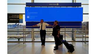 Funcionários da United Airlines aguardando o retorno do sistema Windows em aeroporto em de Newark, Nova Jersey (EUA)