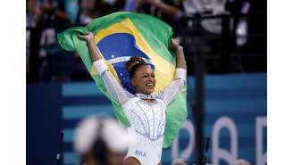 Rebeca Andrade comemora com a bandeira do Brasil após ganhar a prata na ginástica