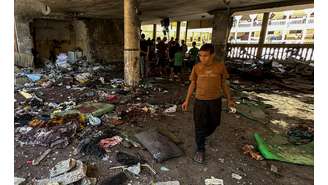 Palestinos observam os danos no local de um ataque israelense a uma escola que abriga pessoas deslocadas, em meio ao conflito Israel-Hamas, na cidade de Gaza, 10 de agosto de 2024.