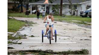 Mulher chora depois de ver danos causados após passagem de tornado antes da chegada do Furacão Milton na Flórida, nos EUA