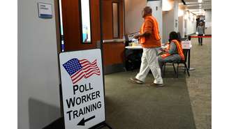 Trabalhadores eleitorais supervisionam a votação antecipada em uma seção eleitoral em Marietta, Geórgia, EUA, 15 de outubro de 2024. 