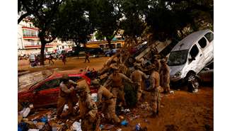 Membros do Exército Espanhol trabalham na limpeza de rua coberta de lama e destroços após enchentes em Massanassa, próximo a Valência, Espanha. (3/11/2014)