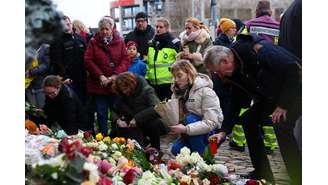 Pessoas deixam velas e homenagens florais às vítimas perto do local onde um carro atropelou uma multidão em um mercado de Natal de Magdeburg, em Magdeburg, Alemanha, em 21 de dezembro de 2024.