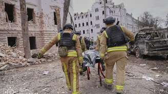 Bombeiros carregam corpo de uma vítima do bombardeio russo contra a cidade de Sumy, no nordeste da Ucrânia, neste domingo, 13 de abril de 2025.