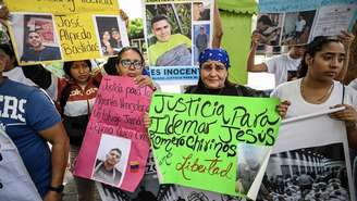 Familiares de migrantes venezolanos deportados dos Estados Unidos a uma prisão de segurança máxiam em El Salvador mostram cartazes durante uma manifestação em frente ao edifício das Nações Unidas em Caracas em 9 de abril de 2025.