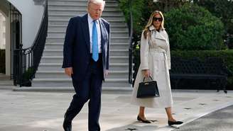 Melania Trump usando casaco de grife ao lado do marido