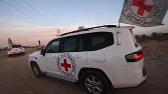 Veículos da Cruz Vermelha Internacional (CICV) transportando o refém americano-israelense Edan Alexander passam por Deir el-Balah. Em 12 de maio de 2025.