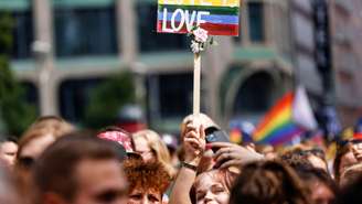 Um participante segura uma placa com os dizeres "Love is Love" durante o protesto do 44º Christopher Street Day (CSD) durante o Mês do Orgulho em Berlim, 23 de julho de 2022.