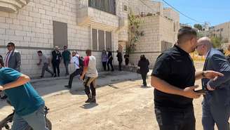 Diplomatas de uma delegação internacional tentam se esconder de disparos durante visita à Cisjordânia ocupada, em 21 de maio de 2025.