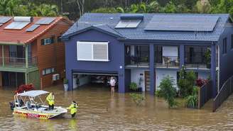 Equipes de resgate ajudam uma moradora ilhada pelas enchentes em sua casa em Port Macquarie, ao norte de Sydney, Austrália