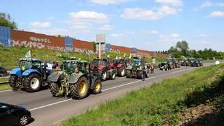 Agricultores afiliados da FNSEA bloqueiam a rodovia A1 com tratores, perto de Lille, em 19 de maio de 2025, para exigir a revogação de regulamentações restritivas.