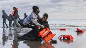Foto ilustrativa: Um migrante sudanês na areia após deixar o barco de um traficante, que foi esvaziado por policiais franceses para impedir a travessia da Mancha. A cena aconteceu na praia de Gravelines, perto de Dunkerque, no norte da França, em 26 de abril de 2024.