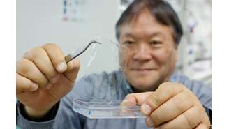 Takuzo Aida, do Centro de Ciência de Materiais Emergentes RIKEN, exibe plástico que se dissolve em água do mar. 