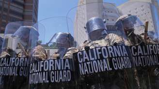Soldados da Guarda Nacional tentam dispersar manifestantes no centro de Los Angeles, em 8 de junho de 2025.