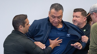 O senador da Califórnia Alex Padilla é empurrado para fora da sala enquanto a secretária de Segurança Interna, Kristi Noem, concede uma entrevista coletiva em Los Angeles na quinta-feira, 12 de junho de 2025