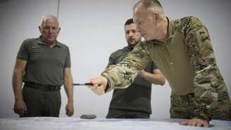 Nesta foto fornecida pelo Gabinete de Imprensa Presidencial da Ucrânia, o presidente ucraniano Volodymyr Zelenskyy, ao centro, e o comandante-chefe Oleksandr Syrsky, à direita, olham para um mapa durante sua visita a Sumy, Ucrânia, quinta-feira, 22 de agosto de 2024.