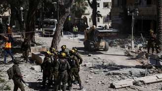 Equipes de resgate se reúnem em um local de impacto após um ataque do Irã em Haifa, Israel, em 22 de junho de 2025.