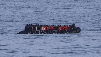 Migrantes navegam a bordo de um barco de contrabandistas em uma tentativa de atravessar o Canal da Mancha na praia de Neufchatel-Hardelot, norte da França, em 18 de junho de 2025.