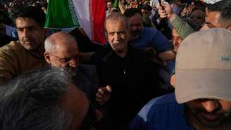O presidente iraniano Massoud Pezeshkian, ao centro, participa de um protesto após ataques dos EUA a instalações nucleares no Irã. Em Teerã, em 22 de junho de 2025.