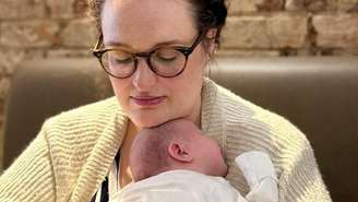 Charlie Beattie segura seu bebê de nove semanas nos braços depois de muitos anos de abortos espontâneos