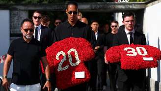 Virgil van Dijk e Andrew Robertson seguram coroas de flores com os números 20 e 30.
