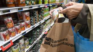 Um cliente coloca um item em uma sacola do "Banco de Alimentos".