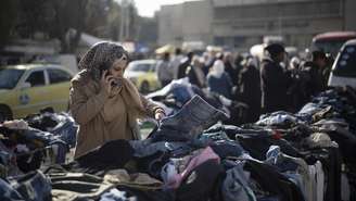 Uma mulher escolhe roupas em um mercado de segunda mão na capital Damasco, na Síria. (Imagem ilustrativa)