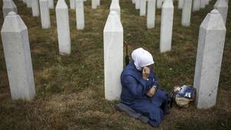 Uma muçulmana bósnia presta homenagem no túmulo de um /parente, vítima do genocídio de Srebrenica. 10/07/25.