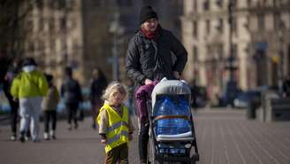 Foto ilustrativa de uma mulher andando com uma criança na Praça da Independência de Kiev.