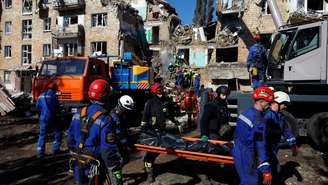 Equipes de resgate removem o corpo de uma pessoa retirada dos escombros no local de um prédio atingido por mísseis e drones russos, em meio ao ataque da Rússia à Ucrânia, em Kiev, Ucrânia, em 28 de agosto de 2025.