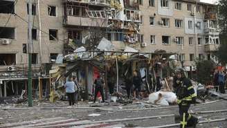 Habitantes em frente a edifícios destruídos depois de um ataque aéreo na cidade de Zaporíjia, em 30 de agosto de 2025.