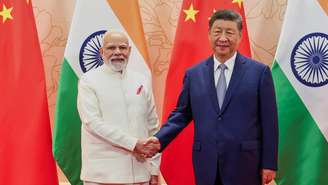 Nesta foto fornecida pelo Gabinete do Primeiro-Ministro da Índia, o primeiro-ministro indiano Narendra Modi, à esquerda, e o presidente chinês Xi Jinping apertam as mãos antes de sua reunião à margem da cúpula da Organização para Cooperação de Xangai (OCX) em Tianjin, China, no domingo, 31 de agosto de 2025.