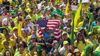 Bandeira dos EUA em meio a pessoas vestidas de verde e amarelo em protesto bolsonarista de 7 de setembro