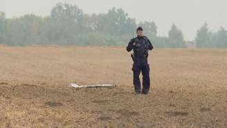 Um policial polonês examina um fragmento de um drone russo em Czesniki, na região de Lublin, na Pologne, em 10 de setembro de 2025.