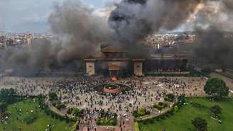 Manifestantes comemoram no prédio do parlamento após ele ter sido incendiado durante um protesto contra a proibição das redes sociais e a corrupção em Katmandu, Nepal, terça-feira, 9 de setembro de 2025.