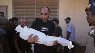 Homem carrega corpo de criança de três anos morta em bombardeio israelense em Deir al-Balah, na Faixa de Gaza, em 14 de setembro de 2025.