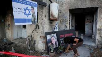 Um integrante do kibutz de Kfar Aza coloca uma vela em homenagem a Ofir Shoshani, uma das vítimas do ataque do Hamas, durante uma cerimônia realizada nesta terça-feira 7 de outubro de 2025 para marcar o segundo aniversário do ataque de 7 de outubro de 2023 contra Israel.