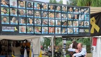 Israelenses se abraçam na “praça dos reféns”, após o anúncio de que Israel e o grupo Hamas haviam chegado a um acordo sobre a primeira fase de um cessar-fogo em Gaza, em 9 de outubro de 2025.