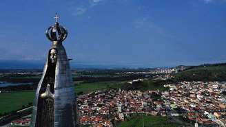 Uma estátua de 50 metros de altura de Nossa Senhora Aparecida, com a cidade de Aparecida ao fundo