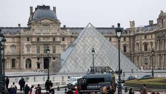 Agentes e veículos da polícia posicionados perto da pirâmide do Museu do Louvre após assalto, em Paris, França, em 19 de outubro de 2025.