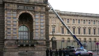 Policiais franceses ao lado da escada elevatória usada por ladrões para entrar no Museu do Louvre, em Paris, em 19 de outubro
