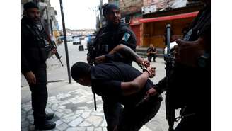 Imagem de um homem detido por agentes da polícia durante a operação policial na favela da Penha, no Rio de Janeiro, nesta terça-feira, 28