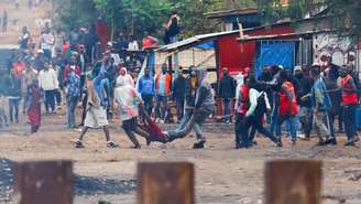 Manifestantes carregam pessoa atingida por disparos em Namanga, na fronteira entre a Tanzânia e o Quênia. (30/10/2025)
