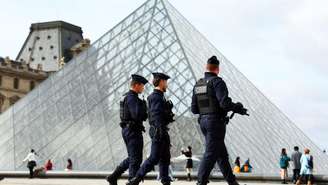 Policiais franceses caminham perto da Pirâmide de Vidro do Museu do Louvre, em Paris, França, em 27 de outubro de 2025.