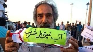 'Aviso: água não potável', diz a garrafa de um manifestante em protesto contra a falta d'água na província iraniana do Sistão-Baluchistão