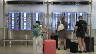 Passageiros consultam a lista de voos no Aeroporto Internacional de Miami