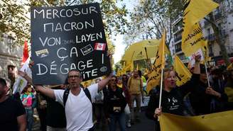 Foto ilustrativa: manifestantes protestam nas ruas de Paris com cartazes criticando a ação do presidente francês, Emmanuel Macron, mas também da presidente da Comissão Europeia, Ursula von der Leyen, na negociação do acordo com bloco com o Mercosul (14/10/25).