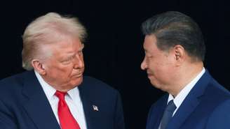 O presidente dos EUA, Donald Trump, e o presidente chinês, Xi Jinping, conversam ao saírem do Aeroporto Internacional de Gimhae após uma reunião bilateral, à margem da cúpula da Cooperação Econômica Ásia-Pacífico (APEC), em Busan, Coreia do Sul, em 30 de outubro de 2025.