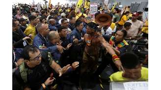 Manifestantes, incluindo indígenas, participam de um protesto enquanto forçam a entrada no local que sedia a Conferência das Nações Unidas sobre Mudanças Climáticas (COP30), em Belém
